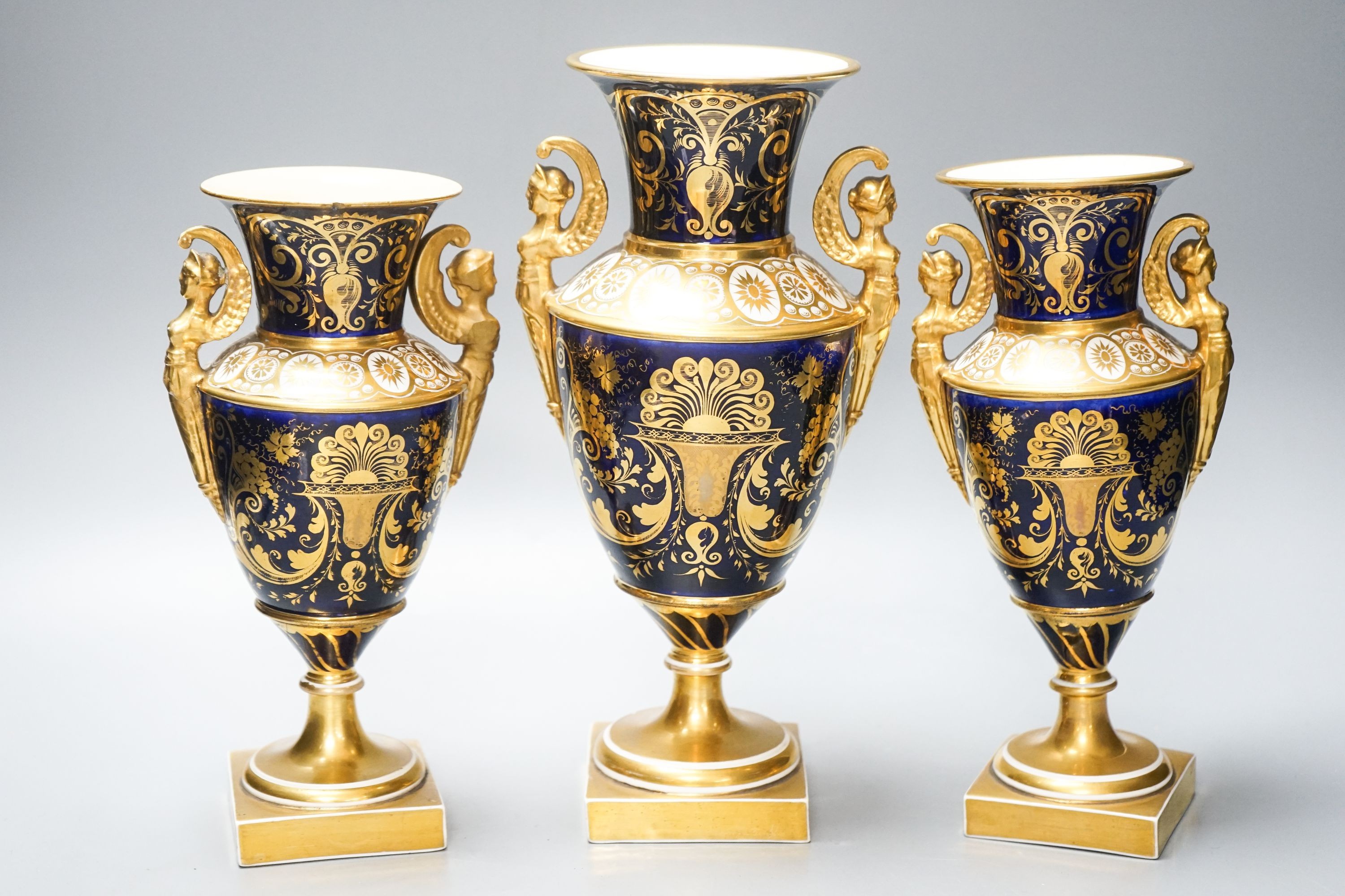 A garniture of three early 19th century English porcelain vases, c.1815-20, each painted with topographical views, tallest 26cm